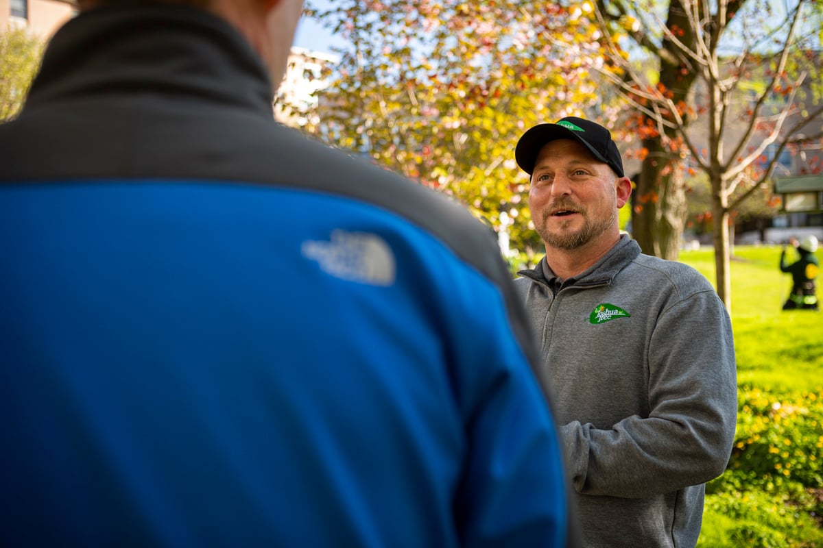 Tree care technician talks with customer