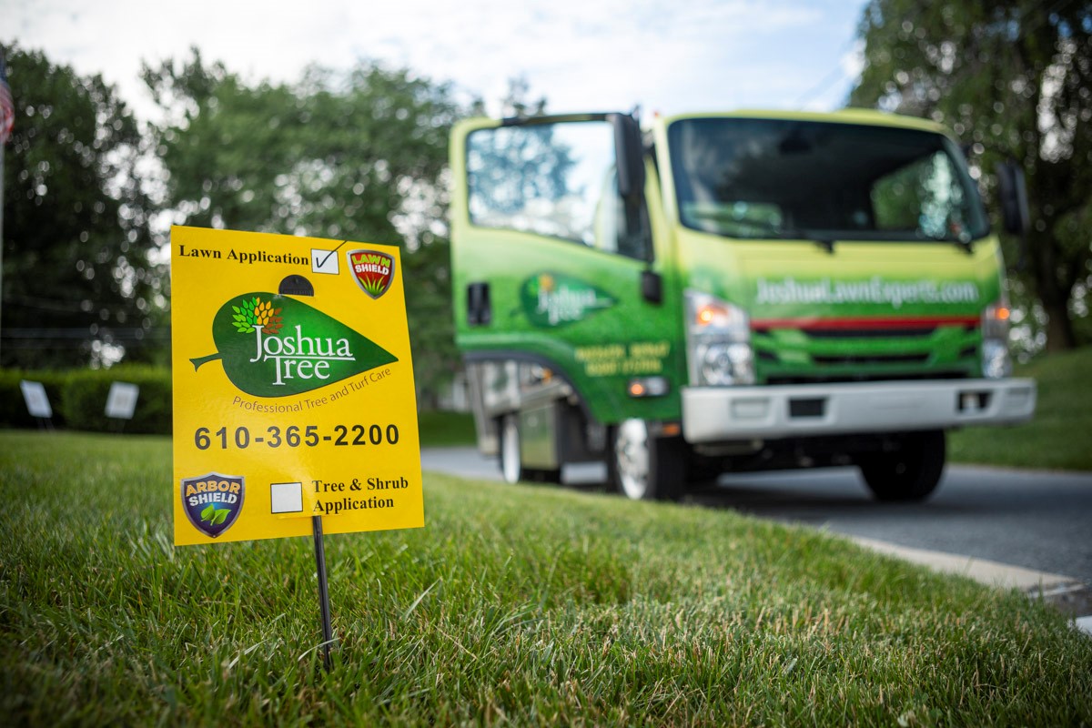 lawn sign with contact information and truck in background