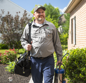 A Joshua Tree Experts professional confidently leaving a client's house after successful pest service treatments. The expert ensures thorough and effective pest control solutions for a satisfied customer.