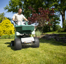 A Joshua Tree Experts professional applying treatment to a lawn. The expert is dedicated to ensuring healthy and vibrant greenery through professional lawn care services.